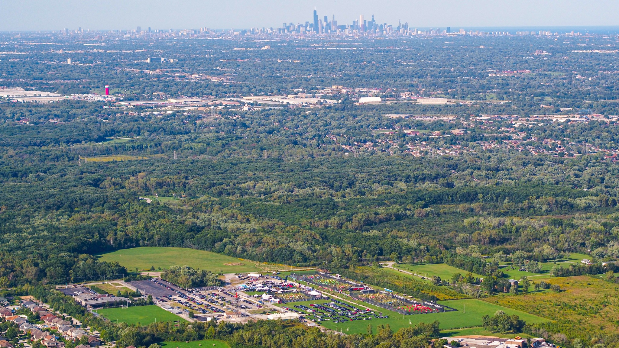 Aerial view of a sporting event and green landscape with the Chicago skyline on the horizon