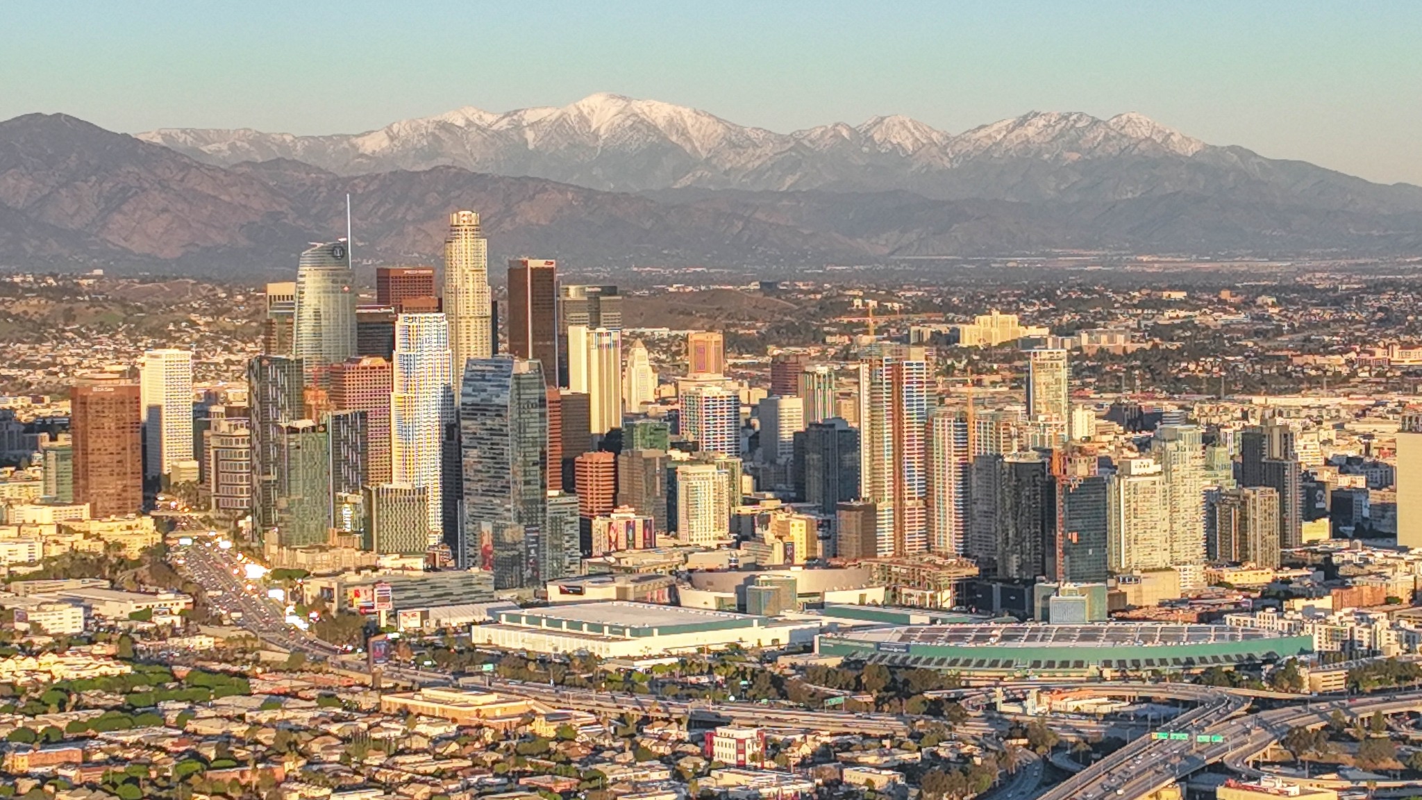 Downtown Los Angeles skyline framed by snow-capped San Gabriel Mountains