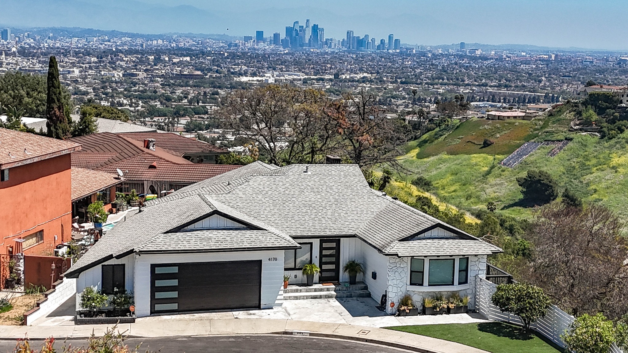 Hillside home photographed from the air with Los Angeles in the distance
