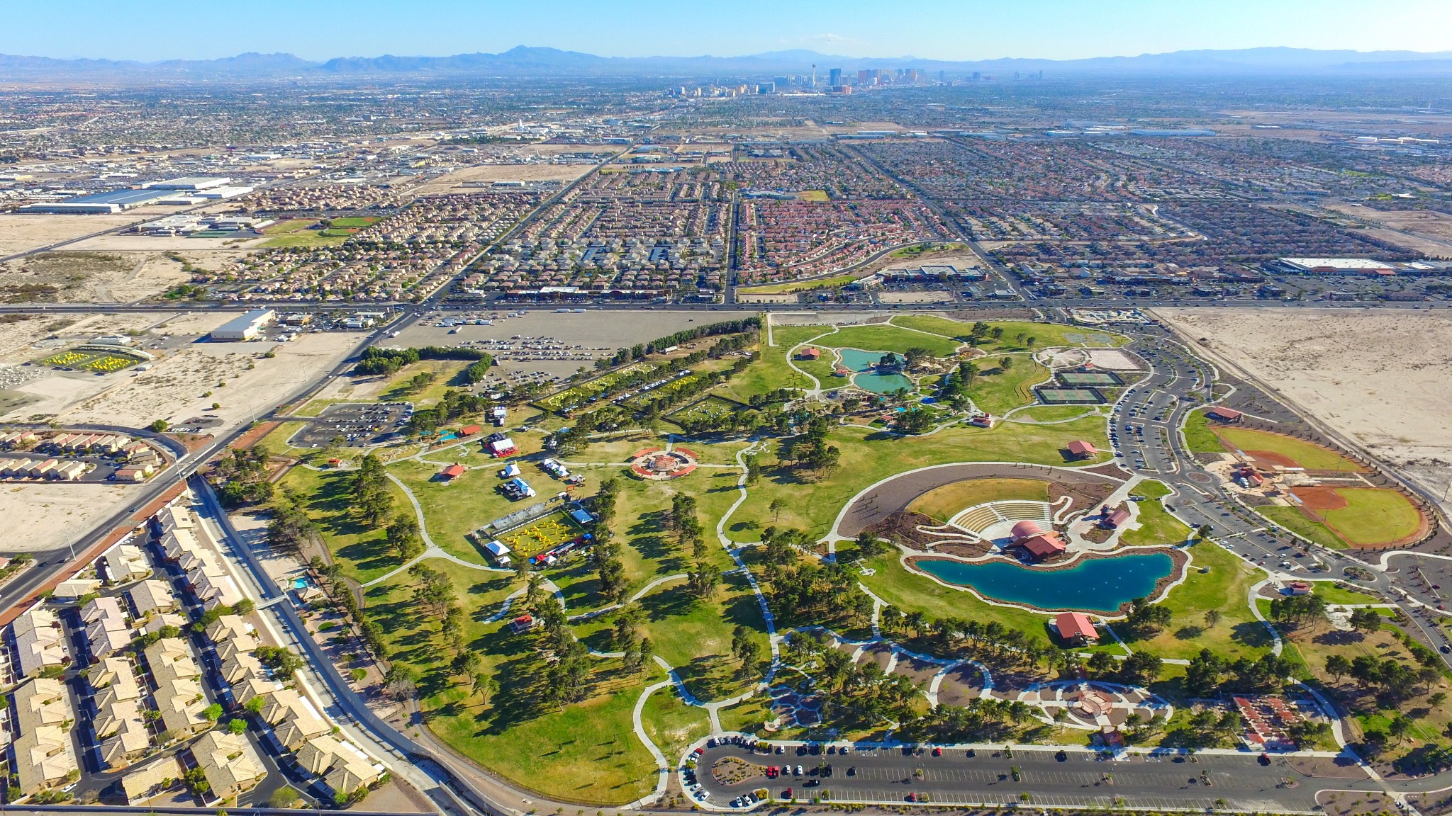 Aerial view of a large green park and event area with Las Vegas in the distance