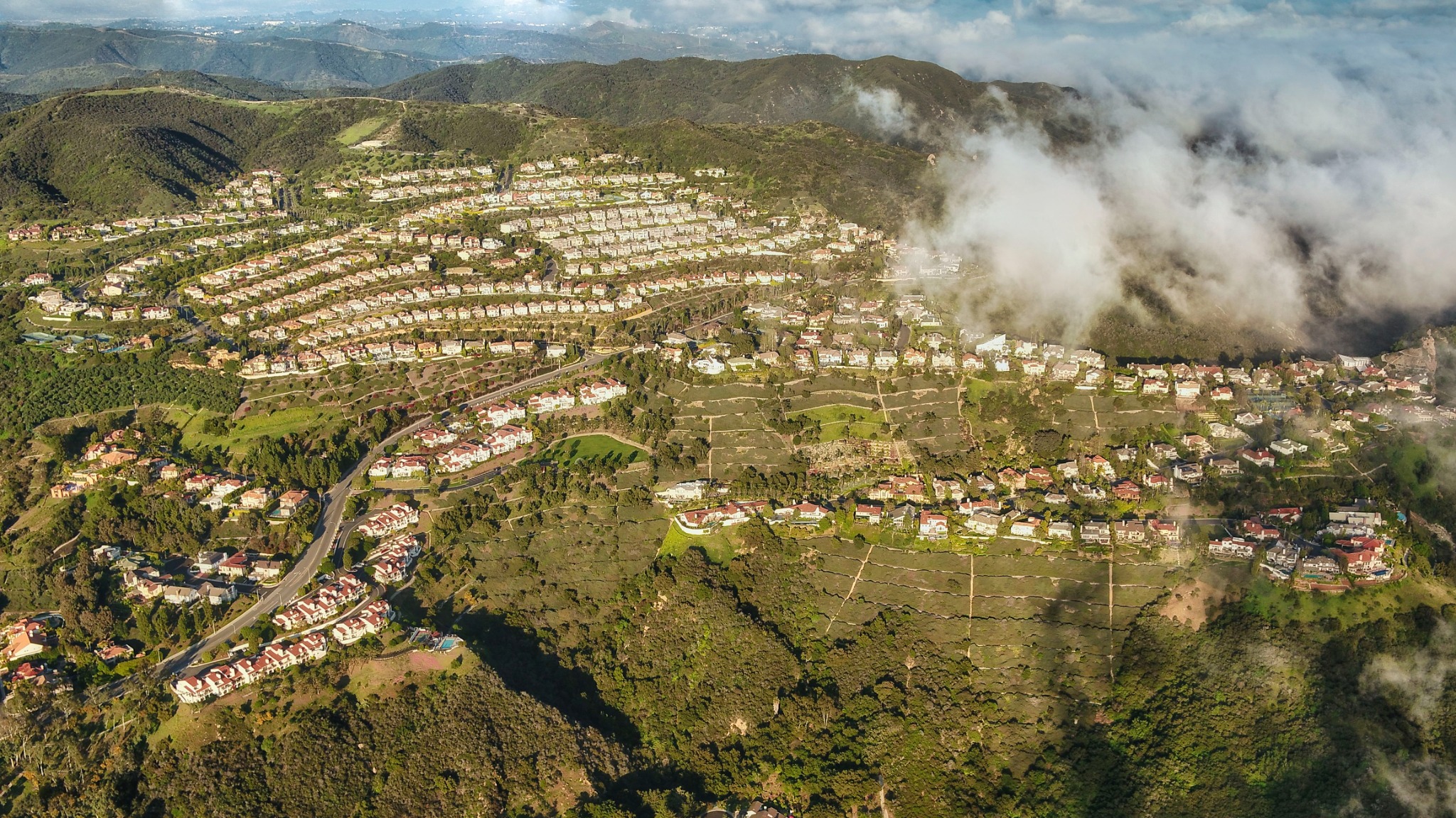 Aerial panorama of the Palisades Highlands with fog moving through the surrounding mountains