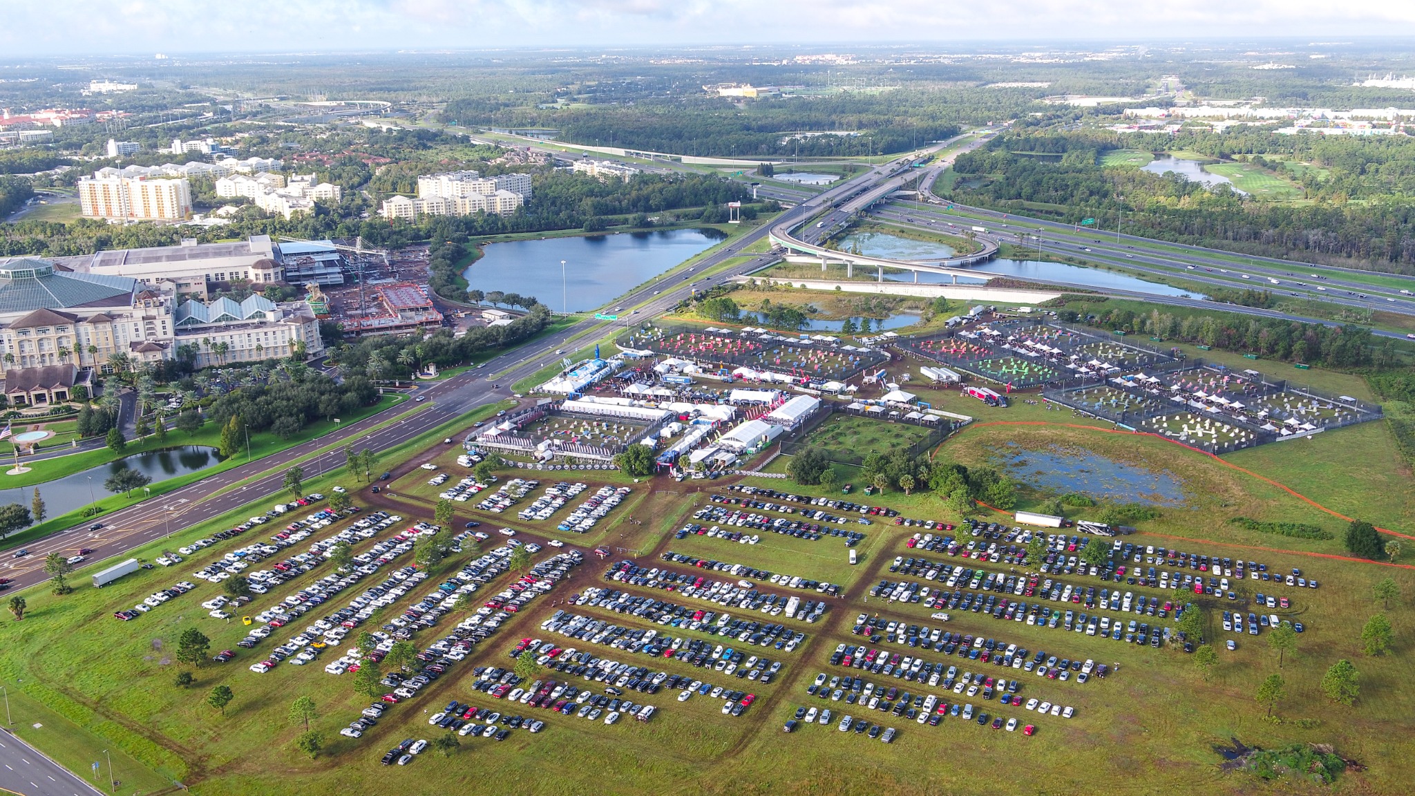 Aerial overview of a large outdoor event, parking fields, highways and resort grounds